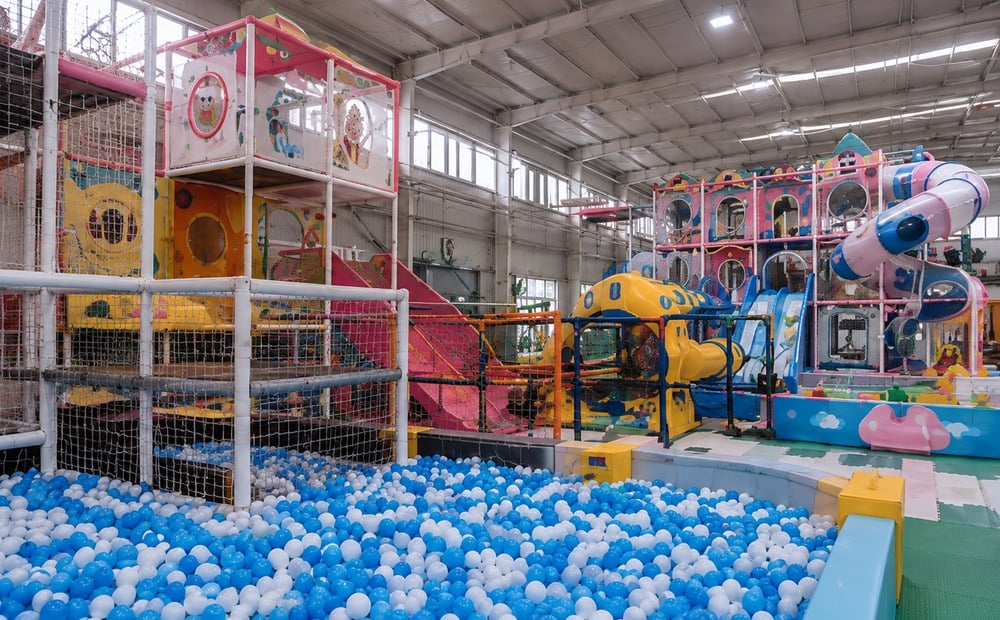 Completed indoor play structure showing ball pool netting and venue envelope